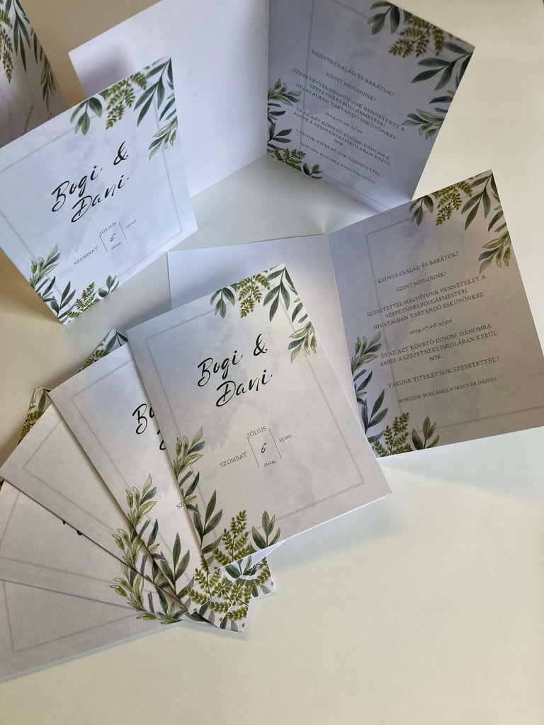 Wedding invitation suite with green botanical leaf designs featuring names Regi and Dani, displayed spread out on white surface