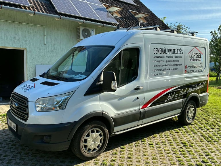 White commercial van parked on brick driveway in front of house with solar panels on roof